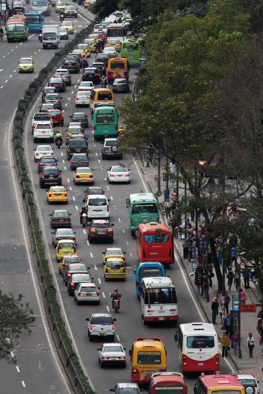 Avenida con carros, taxis y buses en una ciudad colombiana