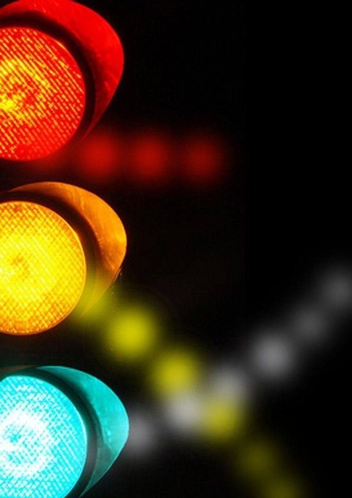 Semáforo encendido en rojo, amarillo y verde de noche